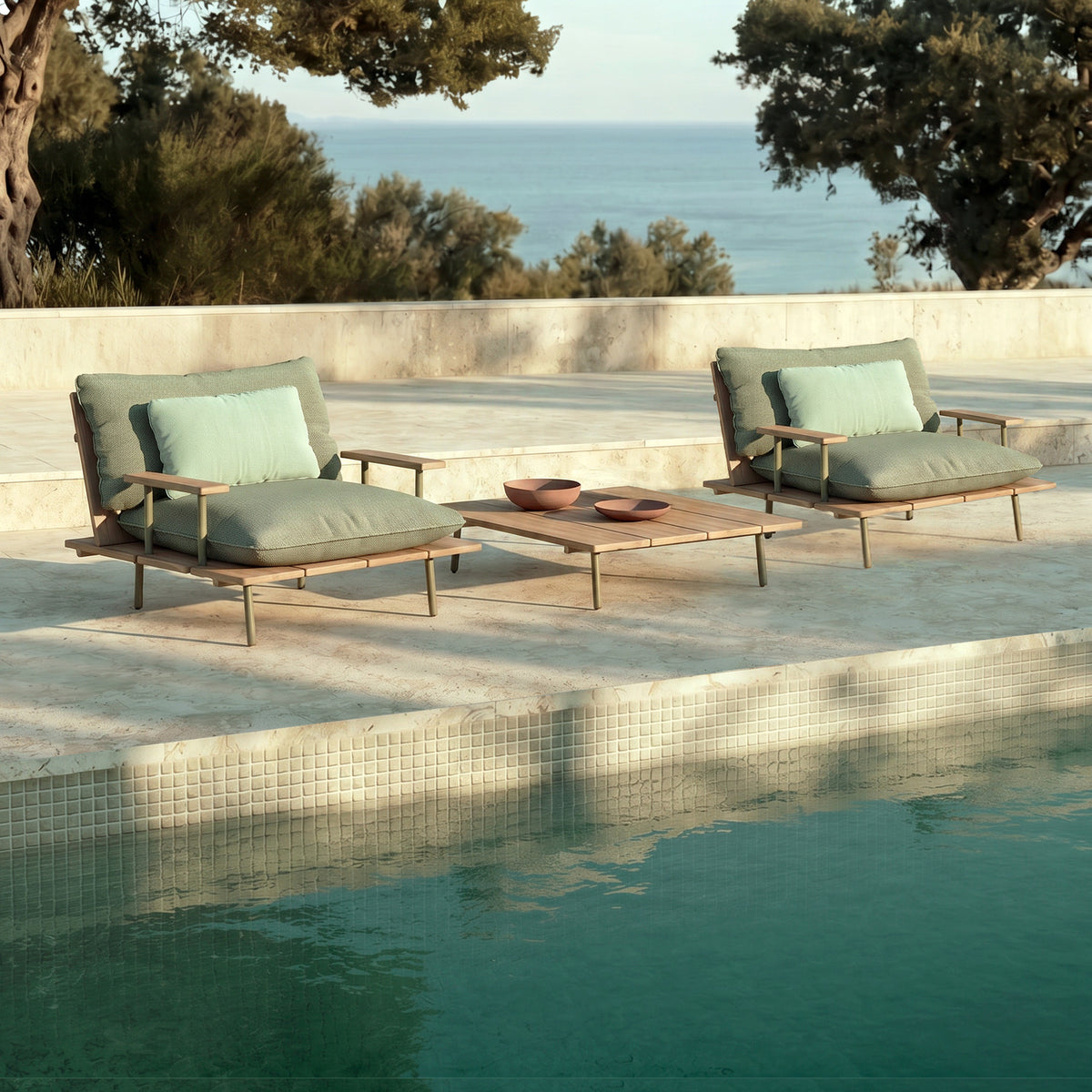 Nami square outdoor coffee table in iroko wood with slatted top and slim aluminium frame, set poolside between two lounge chairs with sage cushions.