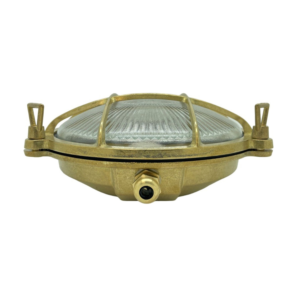 Small Cabin round bulkhead light in raw brass with a ribbed glass dome, brass cage grille, and thumb-turn lugs, shown front-on against a white background.