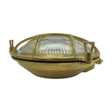 Grand Cabin Round Bulkhead Light IP64 in raw brass, a porthole-style outdoor wall light with caged, ribbed glass and three protruding lugs, shown on a plain white background.