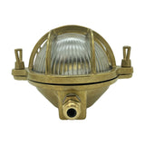 Horatio Oval Bulkhead Light in raw brass, with ribbed glass diffuser behind a crossed brass cage and side mounting lugs, shown on a plain white background.