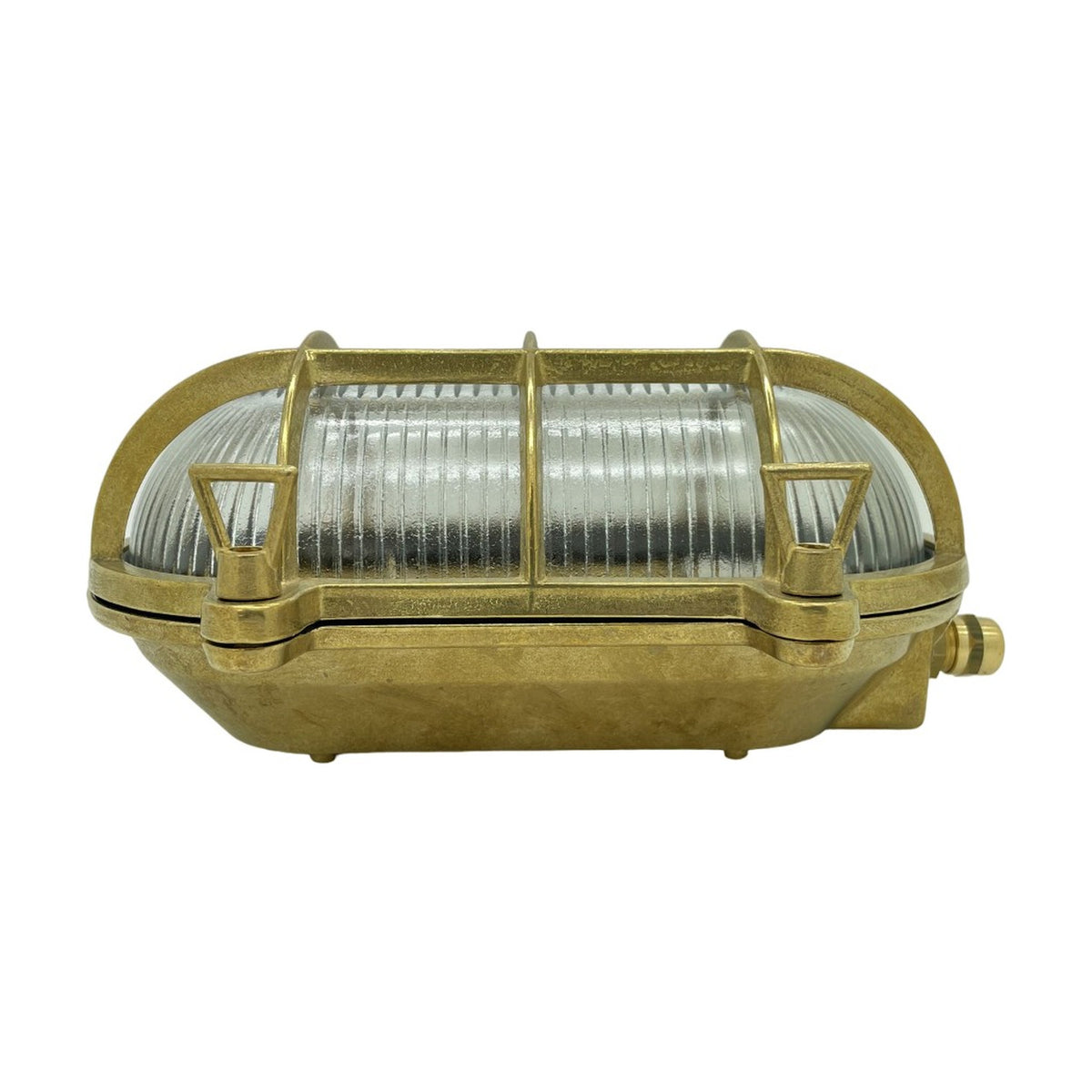 Horatio Oval Bulkhead Light in raw brass with clear ribbed glass diffuser and crossed brass cage bars, IP64 nautical-style wall light on a white background.