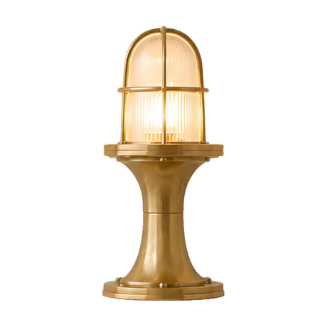 Wellington Outdoor Post Light in raw brass, with a ribbed glass dome encased in a brass guard atop a flared pedestal base, shown lit against a plain white background.