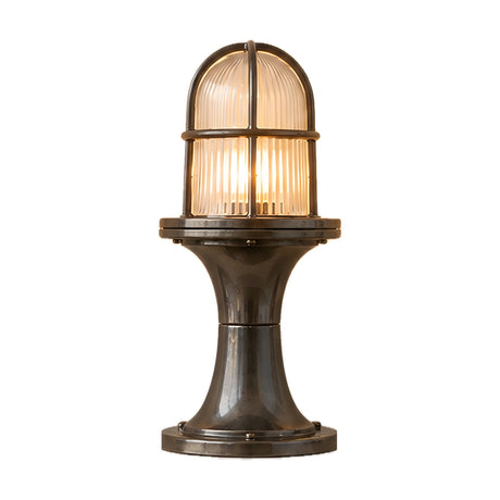 Wellington Outdoor Post Light in antique brass, with a caged ribbed glass dome on a waisted pedestal and round foot plate, IP54 rated, shown on a plain white background.