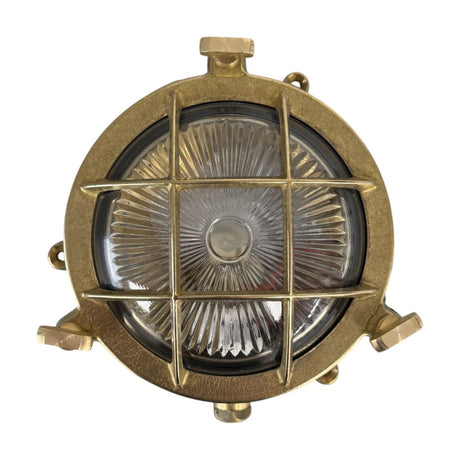 Mini Compass Guard Round Bulkhead Light in raw brass, IP44 rated, with a cross-bar grid guard over domed ribbed glass, shown on a plain white background.