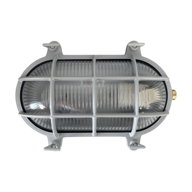 Horatio Oval Bulkhead Light IP64 in silver, showing a brass oval wall light with ribbed glass behind a protective cage and four corner mounting lugs, on a plain white background.