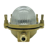 Small Siren oval bulkhead light in raw brass with domed clear ribbed glass cover, cable gland entry and side clamps, shown on a white background.