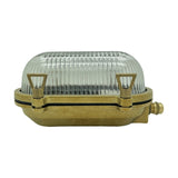 Small Siren oval bulkhead light in raw brass with ribbed glass dome cover and side cable gland, shown on a plain white background.