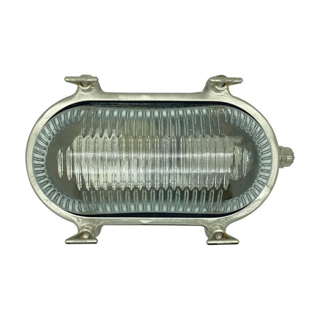 Small Siren Oval Bulkhead Light in satin nickel, solid brass frame with four mounting lugs and clear ribbed glass, IP64 rated, shown on a plain white background.