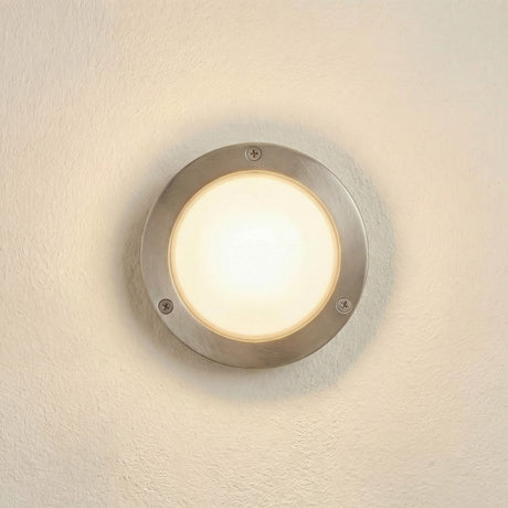 Marina Circular Bulkhead Light IP64 in satin nickel, round brass body with domed frosted glass lens and three bezel screws, illuminated on a plain cream wall.