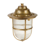 Hull Guard outdoor pendant light in raw brass, with stepped hood, wide brim, and ribbed glass shade encircled by a brass cage guard, shown on a plain white background.