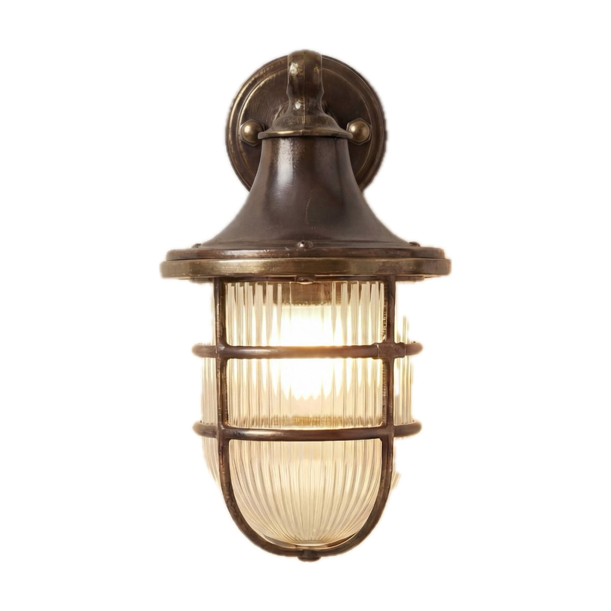 Grand Tiller outdoor wall lantern in antique brass, with bell-shaped hood, ribbed glass shade, brass cage guard, and wall bracket, IP64 rated, shown lit on a white background.