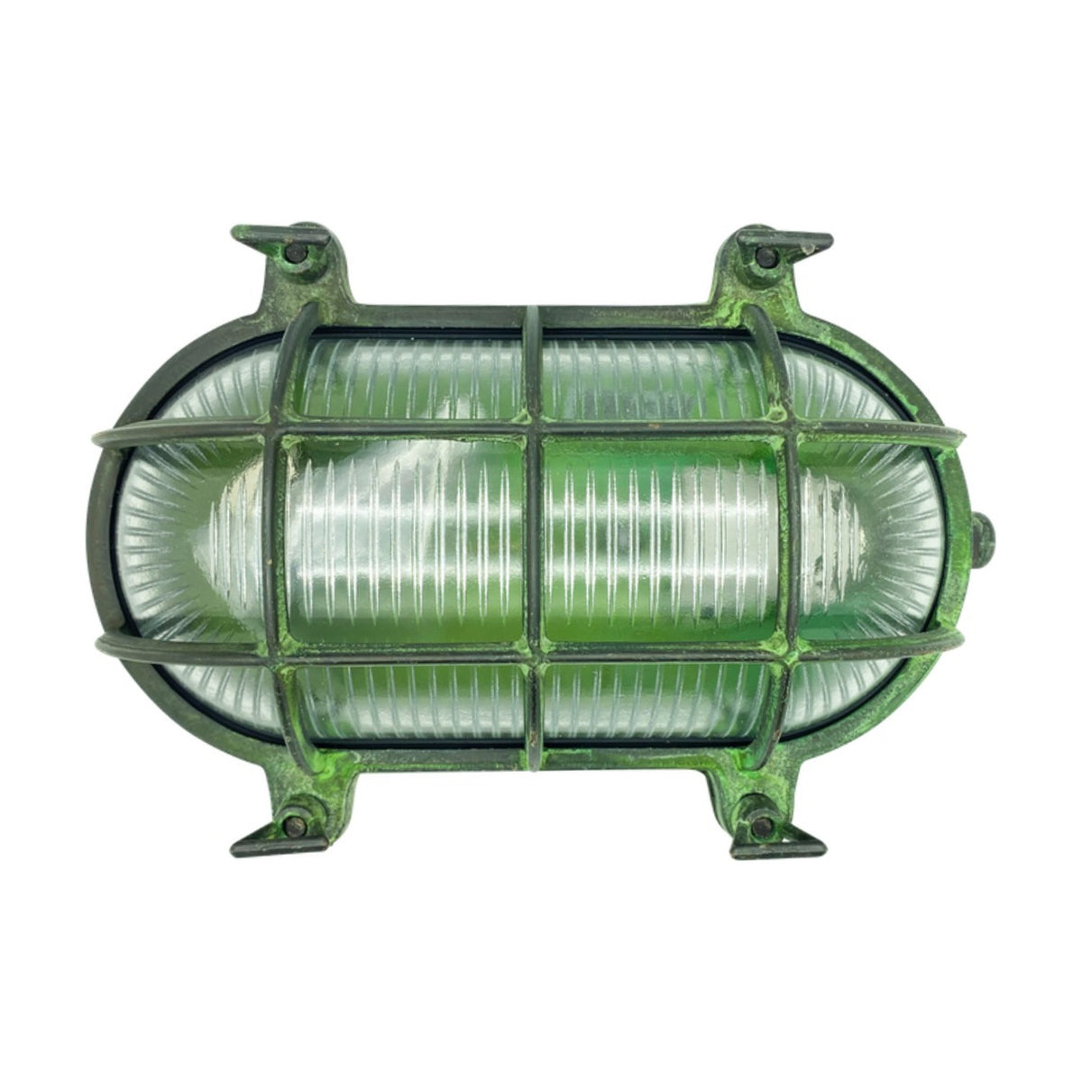 Horatio oval bulkhead light in solid brass with a verdigris finish, protective cage over ribbed glass diffuser, four fixing lugs, IP64 rated, shown on a plain white background.