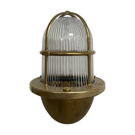Armada Outdoor Wall Lantern in raw brass, caged uplight design with ribbed glass dome and brass bowl base, shown on a plain white background.