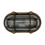Merchant Oval Bulkhead Light in antique brass, with cross-head screws securing a protective cage over ribbed glass, IP64 rated, shown on a plain white background.