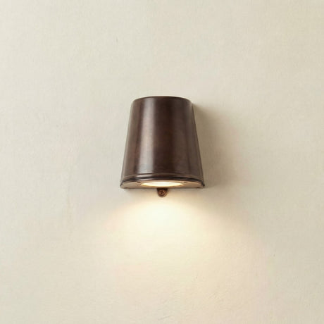 Mast Outdoor Wall Light IP65 in antique brass, a tapered bucket-shaped downlight mounted flat against a plain wall, casting light downward.