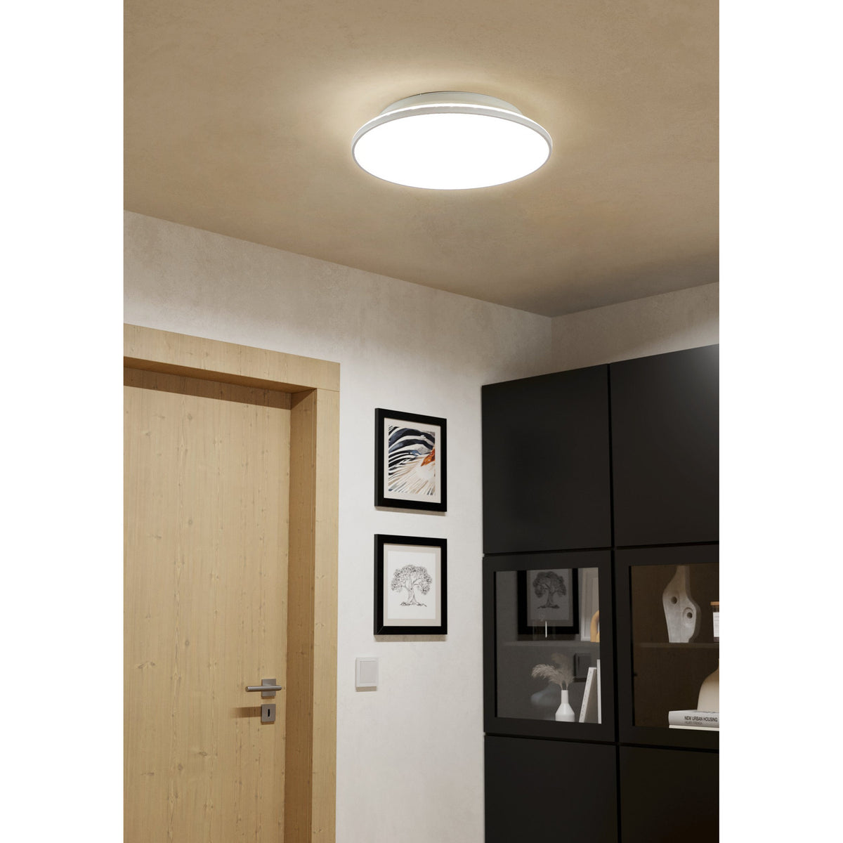 Nelbenne LED Downlight 38cm in white, round and slim-profile, mounted on a hallway ceiling and illuminating a space with a wooden door and black cabinet.