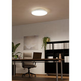 Round white LED downlight, Nelbenne 50cm, fitted flush to the ceiling of a home office with desk, chair and bookshelves below.
