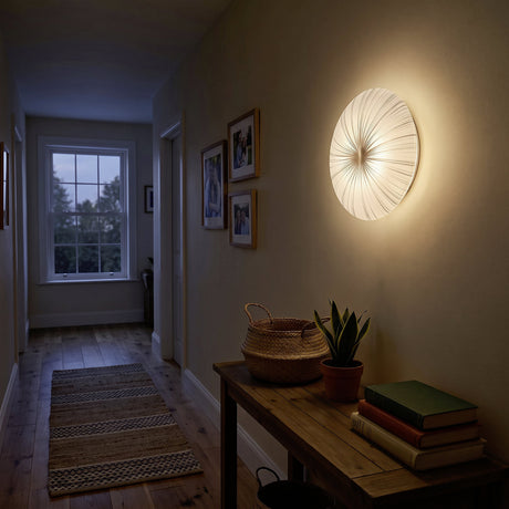 Nieves LED flush ceiling light, 41cm round white diffuser with radiating silver line pattern, glowing warm white on a hallway wall above a console table.