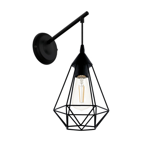 Nilbine Wall Light in black steel, with a round wall plate, angled arm, and cord-hung faceted wire cage shade exposing an E27 bulb, shown on a white background.
