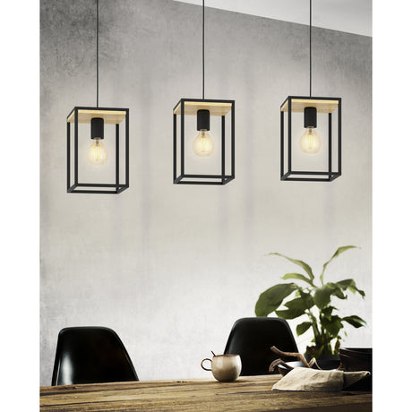 Ninarne Linear Pendant Light with three black steel cube-frame shades topped with wooden panels, each holding an exposed E27 bulb, shown hanging over a dining table.