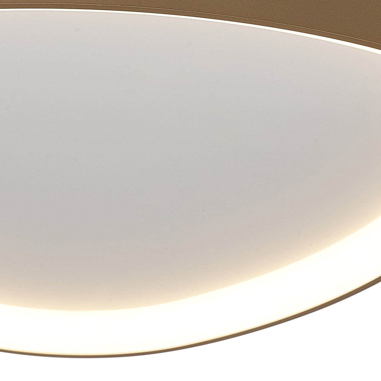 Close-up of the Mantra Niseko flush ceiling light showing its curved gold metal rim and softly illuminated white diffuser with backlit edge glow.