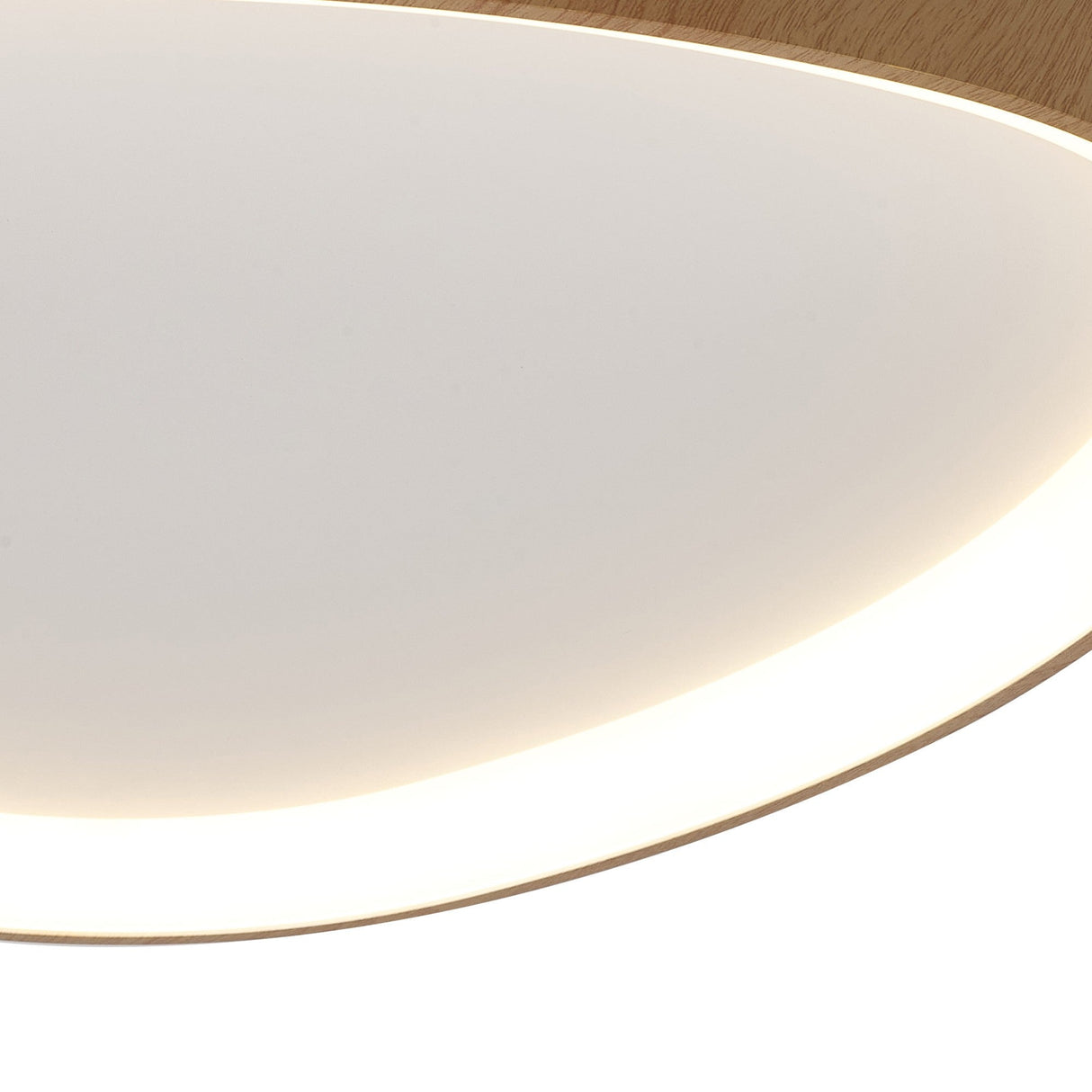 Close-up of the Mantra Niseko LED flush ceiling light showing its white acrylic diffuser panel and light brown wood-effect rim with edge-lit glow.