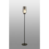 The Nora 1 Light Chrome Glass Floor Lamp features a slim black stand, a black marble base, and a translucent glass shade that softly diffuses light, all set against a plain gray background.