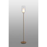 The Nora 1 Light Clear Glass Floor Lamp features a slim gold and white stand with a round base, topped by a clear glass shade that softly glows, adding elegant modern lighting to your space.