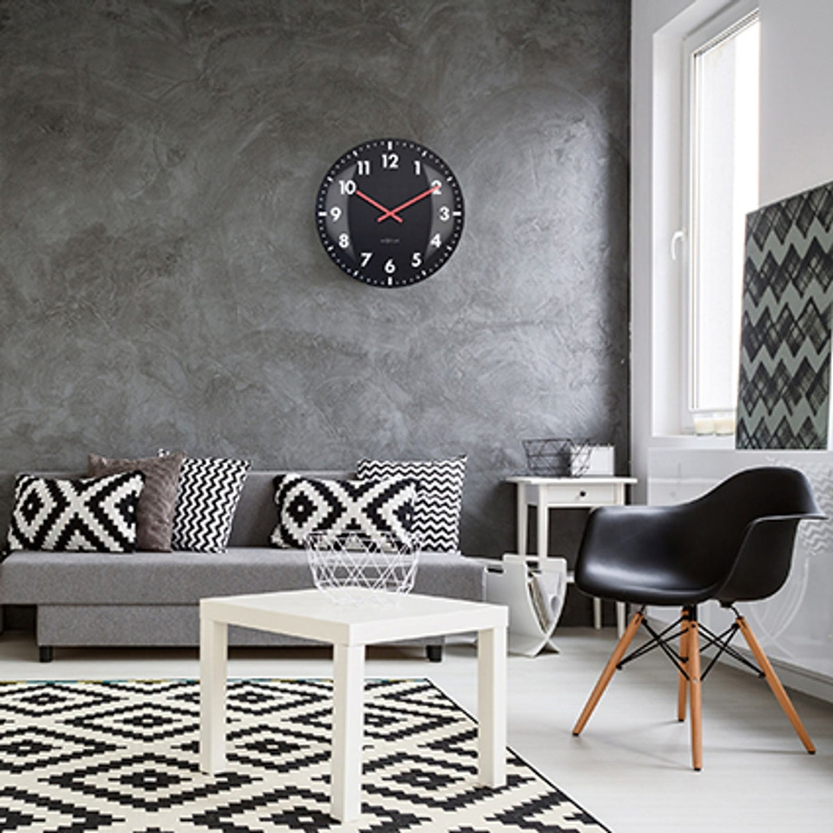 Duomo Domed Glass Wall Clock, 50cm round black face with white numerals and red hands, shown mounted on a grey textured wall in a living room setting.