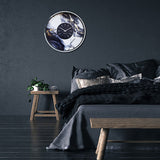Marble Duo Round Aluminium Wall Clock 48cm in Silver & White, with a black centre dial and silver baton markers, shown on a dark bedroom wall above the bed.