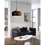 Obregon Pendant Light in brown steel with cream interior and oak-toned crown, dome shade on black cable, shown above a black sofa in a living room setting.