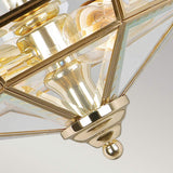 Close-up of the Old Park 2 Light Semi Flush - Polished Brass, a geometric gold and glass chandelier featuring intricate details. This ceiling fixture highlights polished brass accents and reflective surfaces, capturing light beautifully.