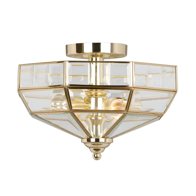 The Old Park 2 Light Semi Flush - Polished Brass is a modern, geometric ceiling fixture crafted from polished brass and glass panels, featuring two visible bulbs. Its angular shape resembles a faceted gem, adding a sophisticated touch to any room with its warm metallic glow.