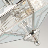 Close-up of the Old Park 2 Light Semi Flush in polished nickel, featuring a geometric design with metallic and glass elements. It showcases reflective surfaces with multiple angles and intersecting lines, all centered around a small decorative finial.