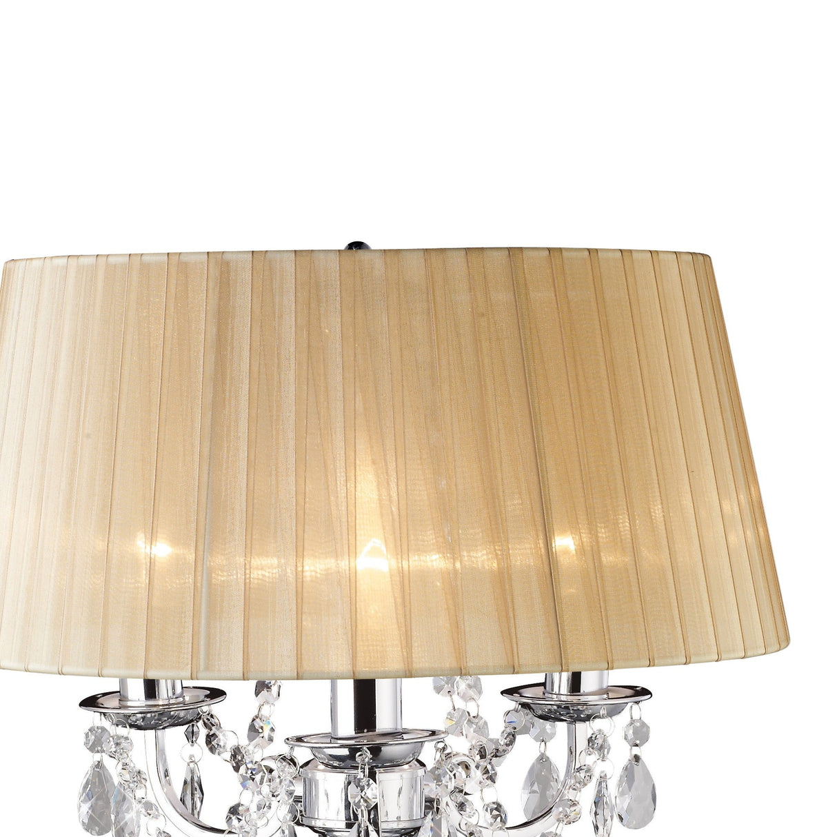 A close-up of the Olivia 3 Light Crystal Table Lamp in chrome, featuring sparkling crystal accents and a soft bronze shade. The lamp is on, casting elegant, dimmable light against a white background.