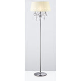 The Olivia 3 Light Crystal Floor Lamp in chrome features a cream pleated shade, hanging crystal accents, and a round base with a tall stand, shown against a plain white background.