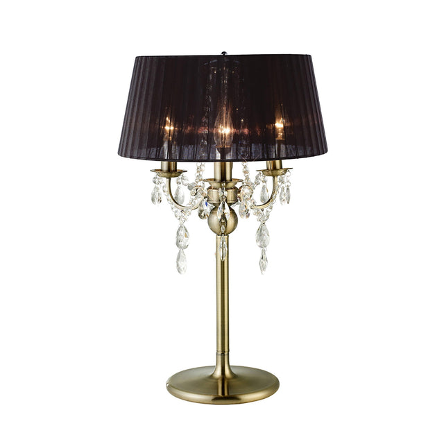 The Olivia 3 Light Crystal Table Lamp features an antique brass finish, black pleated shade, crystal pendants, and three candle-like bulbs on multiple arms for an elegant, classic look.