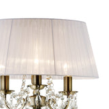 The Olivia 3 Light Crystal Floor Lamp features a brass finish, crystal accents, candle-style bulbs, and is topped with a large pleated white shade for classic elegance.
