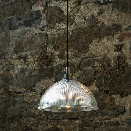 Olvane Ribbed Glass Pendant Light IP65 with clear ribbed dome shade and silver fitting, shown hanging against a weathered stone wall.