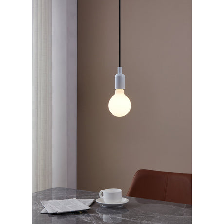 Opal Dimmable LED Globe Bulb E27 G95 glowing warm white in a white pendant fitting above a dining table, set against a soft brown wall.