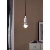 Opal LED GLS bulb, E27 fitting, glowing white in a white pendant fixture against a warm brown wall in a bedroom setting.
