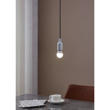 Pendant light with white E27 holder and opal LED golf ball bulb illuminated above a marble table with teacup and newspaper in a muted brown dining setting.