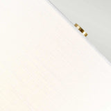 Close-up of a textured white surface resembling the White Shade of the Orb 1 Light Table Lamp, with a small, round detail in an Aged Brass finish positioned at the top right corner. The image is angled, producing diagonal lines across the frame.