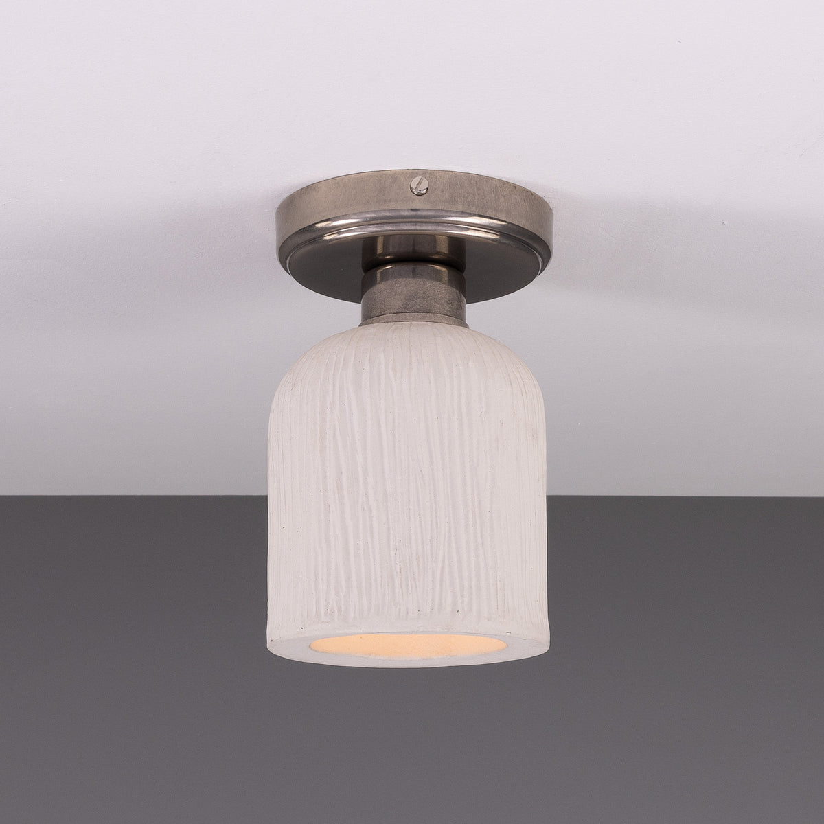 Osier Ceramic Flush Ceiling Light in Matt White Striped glaze, a single-light fixture with a textured bell-shaped shade on a round silver-toned ceiling plate, shown against a plain grey background.