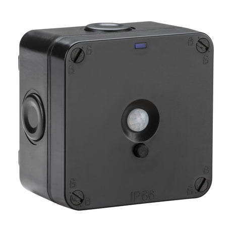 Outdoor PIR sensor in black polycarbonate, square box with round motion sensor lens, push button, photocell dome, blue indicator light, and corner screws, IP66 rated, on a white background.
