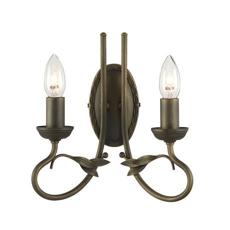 The Olivia 2 Light Wall Light - Black/Gold Patina showcases a vintage-style bronze sconce with two candle-like lights and curved arms accented by leaf details. This handcrafted piece brings elegant symmetry to your decor, enhanced by a classic Black/Gold Patina finish.