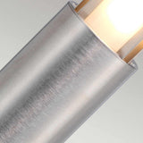 A close-up of the Paignton 1 Light Bollard in stainless steel showcases its sleek, cylindrical shape with a brushed texture and frosted glass that emits a warm glow. Its minimalist design, resembling a vertical bollard, adds a modern aesthetic against a neutral backdrop—ideal for enhancing elegance in outdoor lighting.