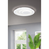 Palagiano 1 LED flush ceiling light, 38cm round white fitting with offset stepped rings, shown illuminated on a grey ceiling above a window and green plant.