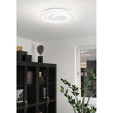 Palagiano 1 LED flush ceiling light, 48cm round white fixture with off-centre stepped rings, shown illuminated on a living room ceiling above a dark cabinet.