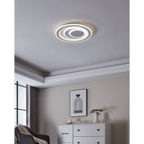 Palagiano 1 LED flush ceiling light, 48cm round white fixture with off-centre stepped rings, installed on a bedroom ceiling above a white chest of drawers.